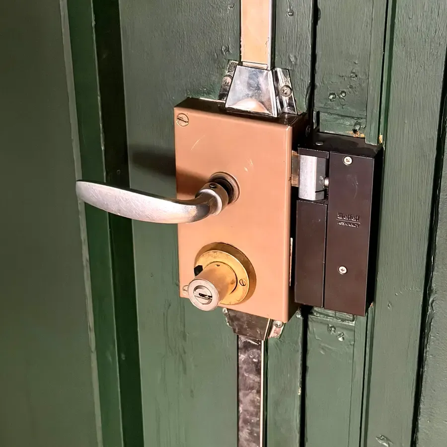 Verrou 3 points en applique laiton sur une porte ancienne verte, Lyon